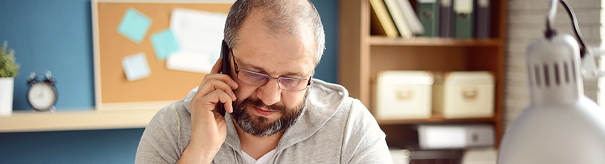 A man in an office uses a telephone